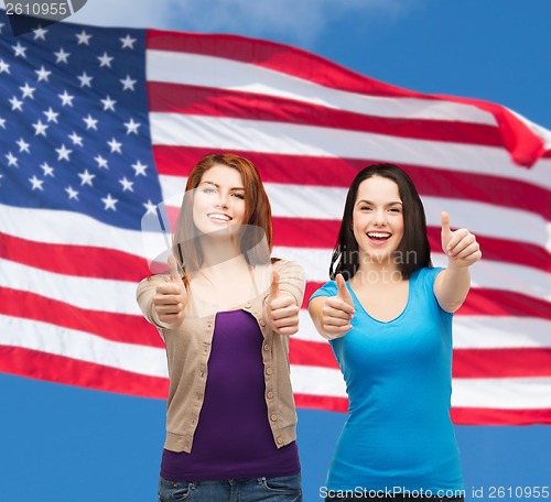 Image of two smiling girls showing thumbs up