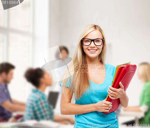 Image of smiling student with folders in eyeglasses