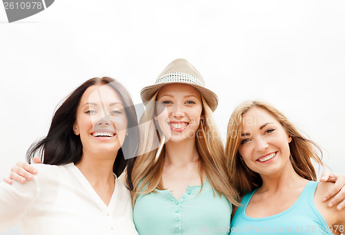 Image of group of smiling girls chilling on the beach