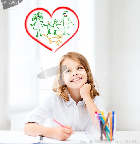 Image of smiling little student girl drawing at school