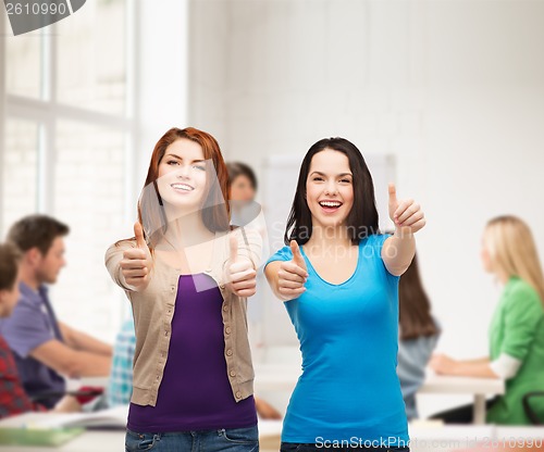 Image of two smiling girls showing thumbs up