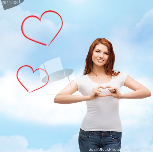 Image of smiling girl showing heart with hands