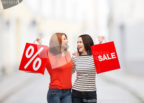 Image of two smiling teenage girl with shopping bags