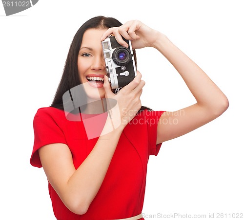 Image of smiling woman taking picture with digital camera