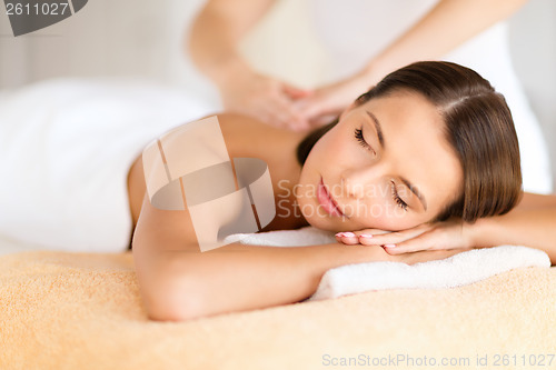 Image of beautiful woman in spa salon getting massage