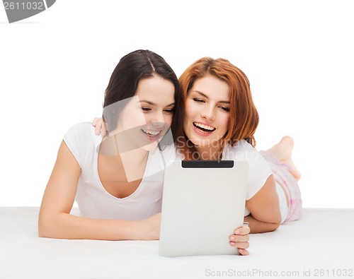 Image of two smiling teenage girsl with tablet pc computer