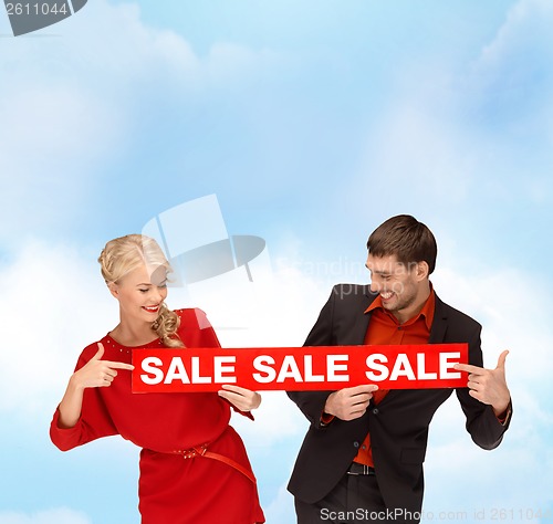 Image of woman and man with red sale sign