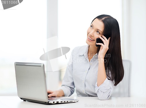 Image of businesswoman with laptop and cell phone