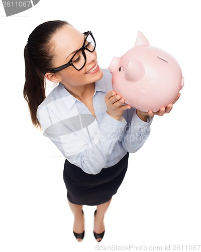 Image of happy businesswoman in eyeglasses with piggy bank