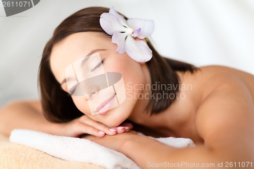 Image of beautiful woman with flower in her hair in spa