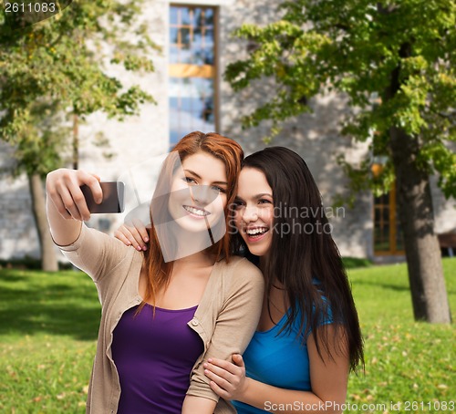 Image of two smiling teenagers with smartphone