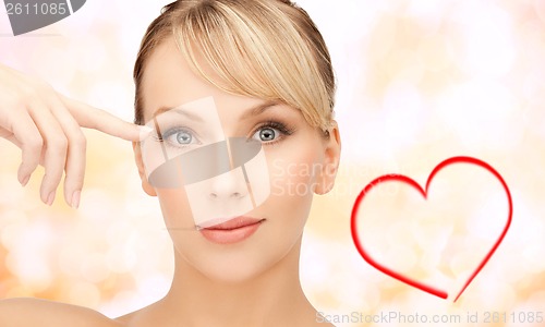 Image of beautiful woman touching her eye area