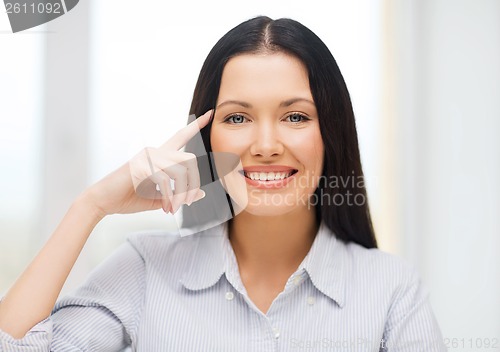 Image of smiling woman pointing to imaginy glasses