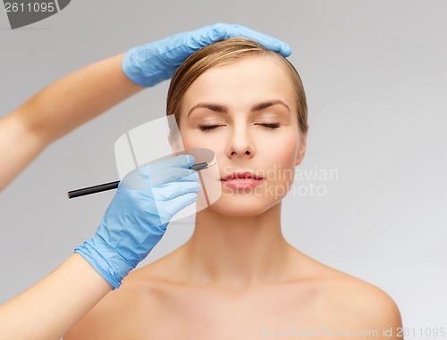 Image of woman face and beautician hands with pencil