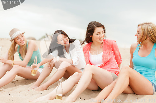 Image of smiling girls with drinks on the beach