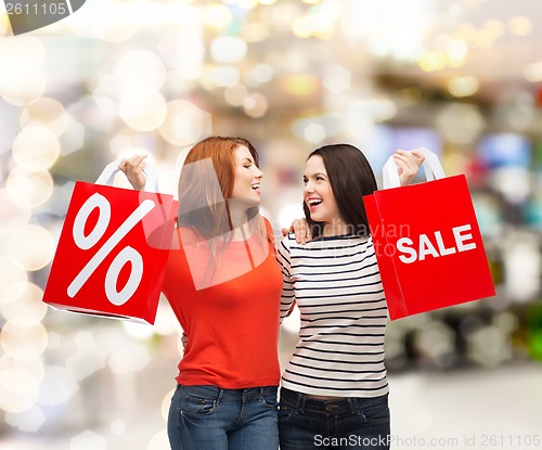 Image of two smiling teenage girl with shopping bags