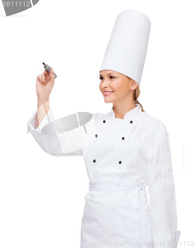 Image of smiling female chef writing something on air