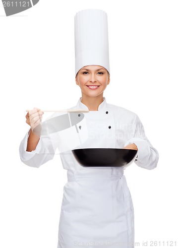 Image of smiling female chef with pan and spoon