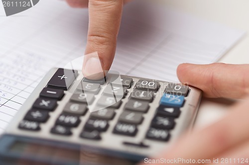 Image of close up of businessman with papers and calculator