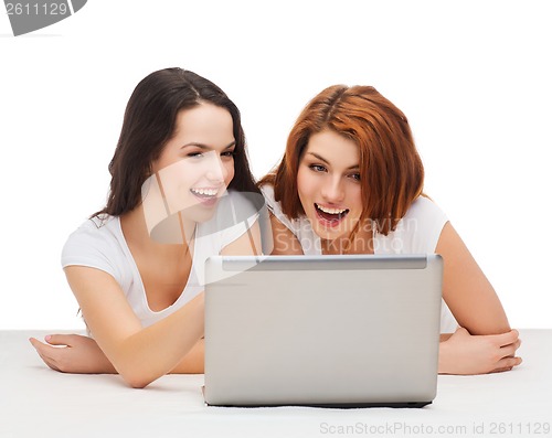 Image of two smiling teenage girsl with laptop computer