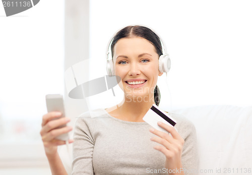 Image of woman with smartphone and headphones at home