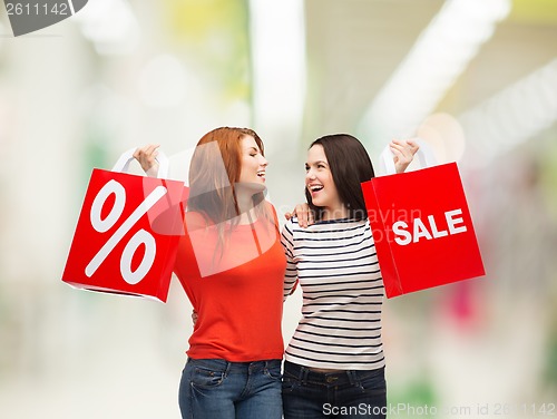 Image of two smiling teenage girl with shopping bags