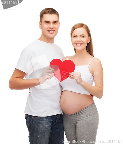 Image of happy young family expecting child with big heart