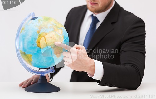 Image of businessman pointing finger to earth globe