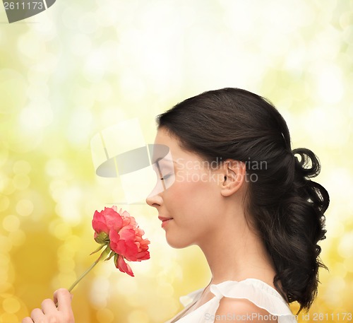 Image of smiling woman smelling flower