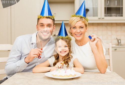 Image of smiling family in blue hats blowing favor horns