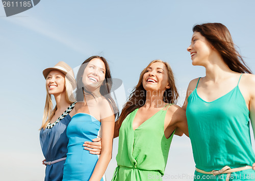 Image of smiling girls walking on the beach