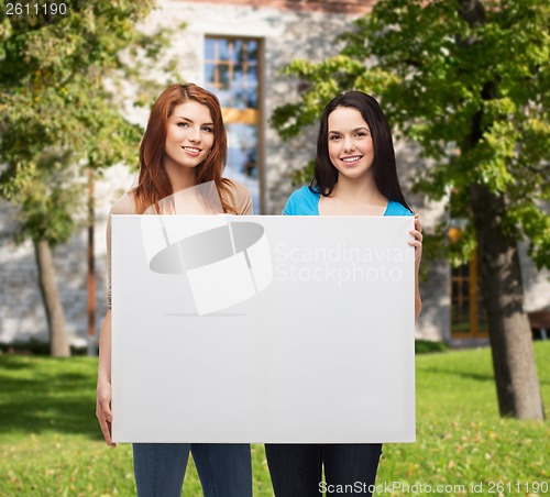 Image of two smiling young girls with blank white board