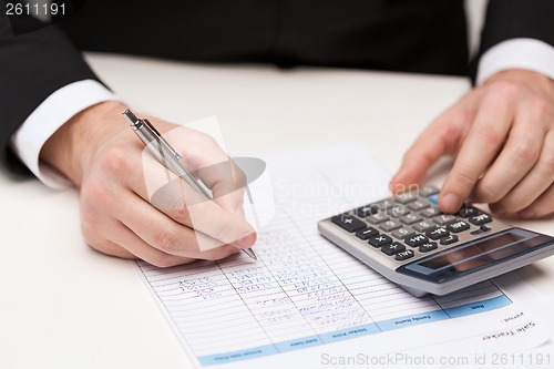 Image of close up of businessman with papers and calculator