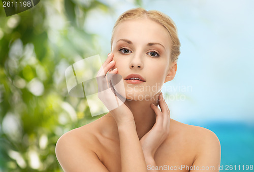 Image of woman touching her face skin