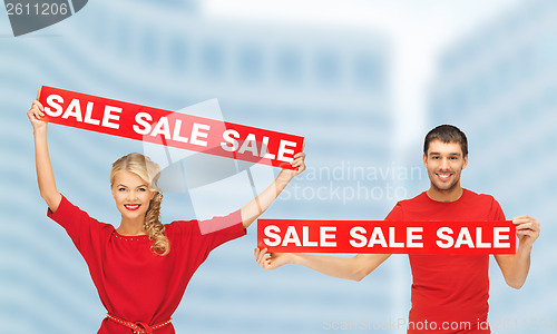 Image of woman and man with red sale signs