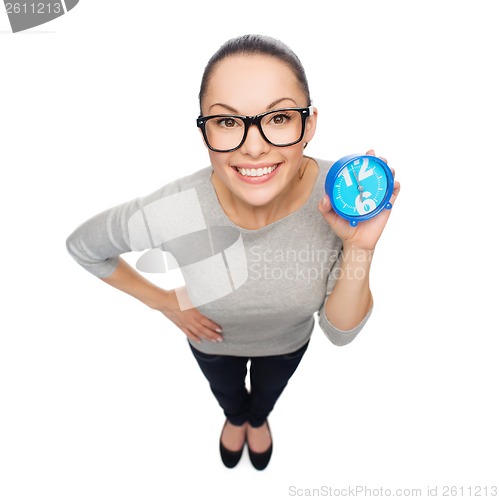 Image of smiling woman in eyeglasses with blue clock