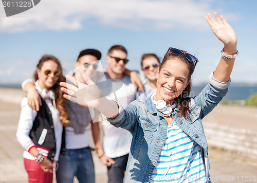 Image of teenage girl with headphones and friends outside