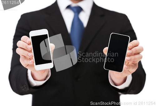 Image of businessman showing smartphones with blank screens