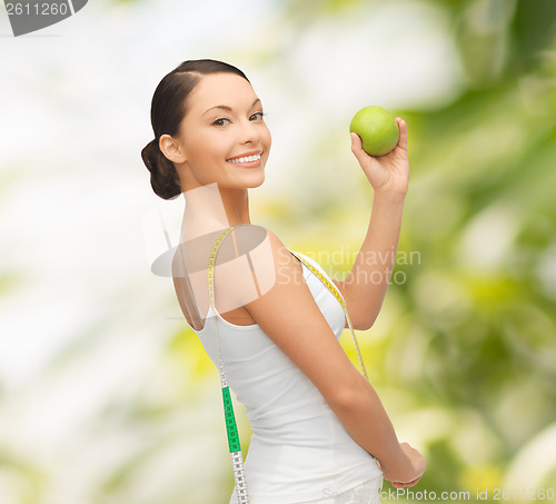 Image of sporty woman with apple and measuring tape
