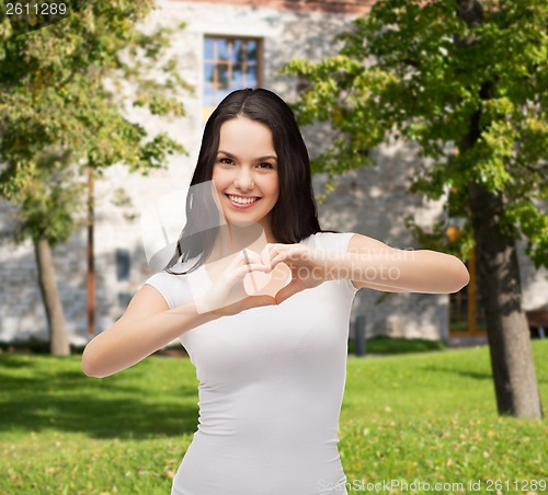 Image of smiling girl showing heart with hands