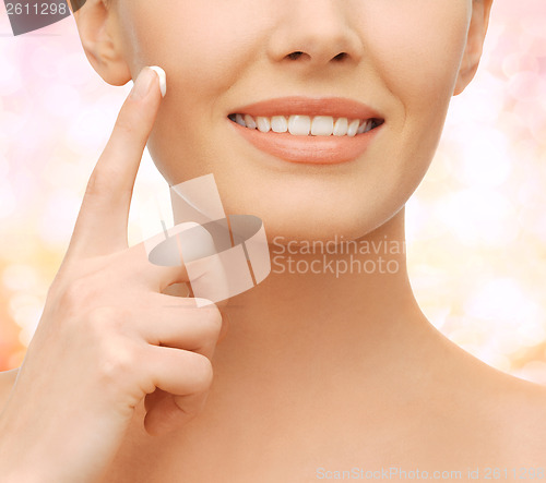 Image of beautiful woman applying moisturizing cream