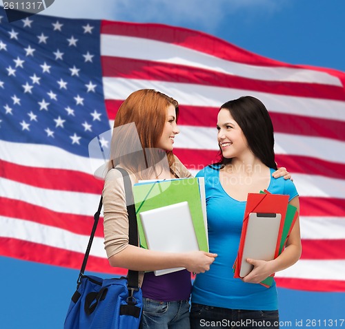 Image of two smiling students with bag and folders