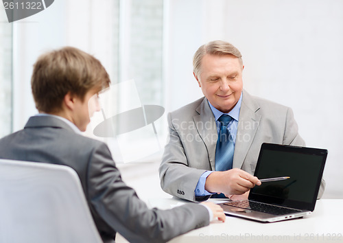 Image of older man and young man with laptop computer