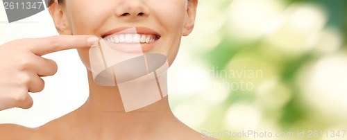 Image of beautiful woman pointing to teeth