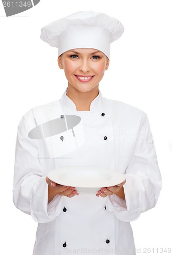 Image of smiling female chef with empty plate