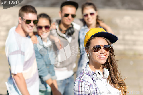 Image of teenage girl with headphones and friends outside