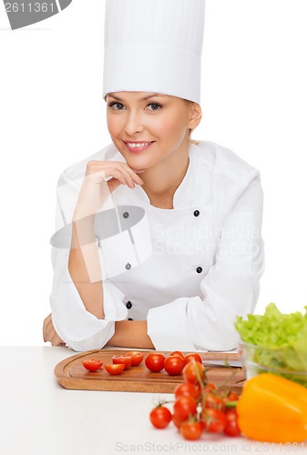 Image of smiling female chef with vagetables