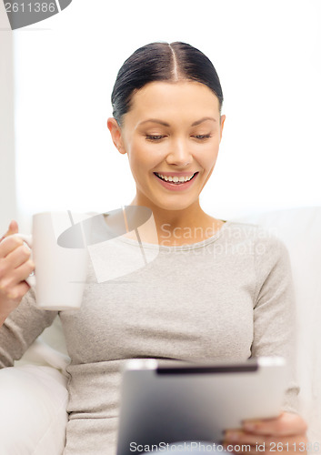 Image of smiling woman with tablet pc computer and cup