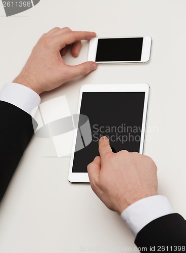 Image of businessman working with tablet pc and smartphone