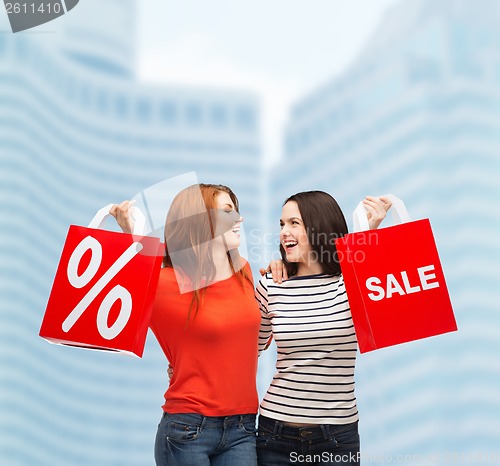 Image of two smiling teenage girl with shopping bags